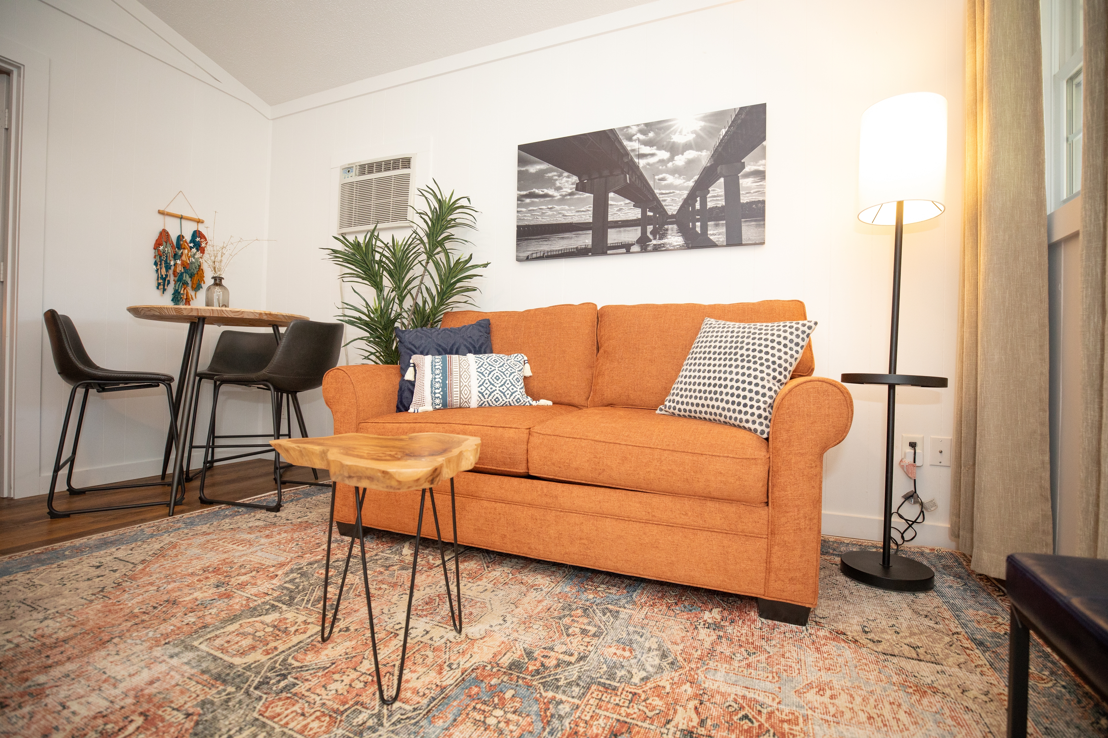 living room with sofa bed, table and bar stools