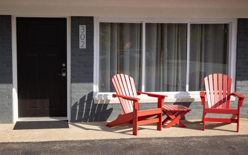 exterior door of room with two red adirondack chairs