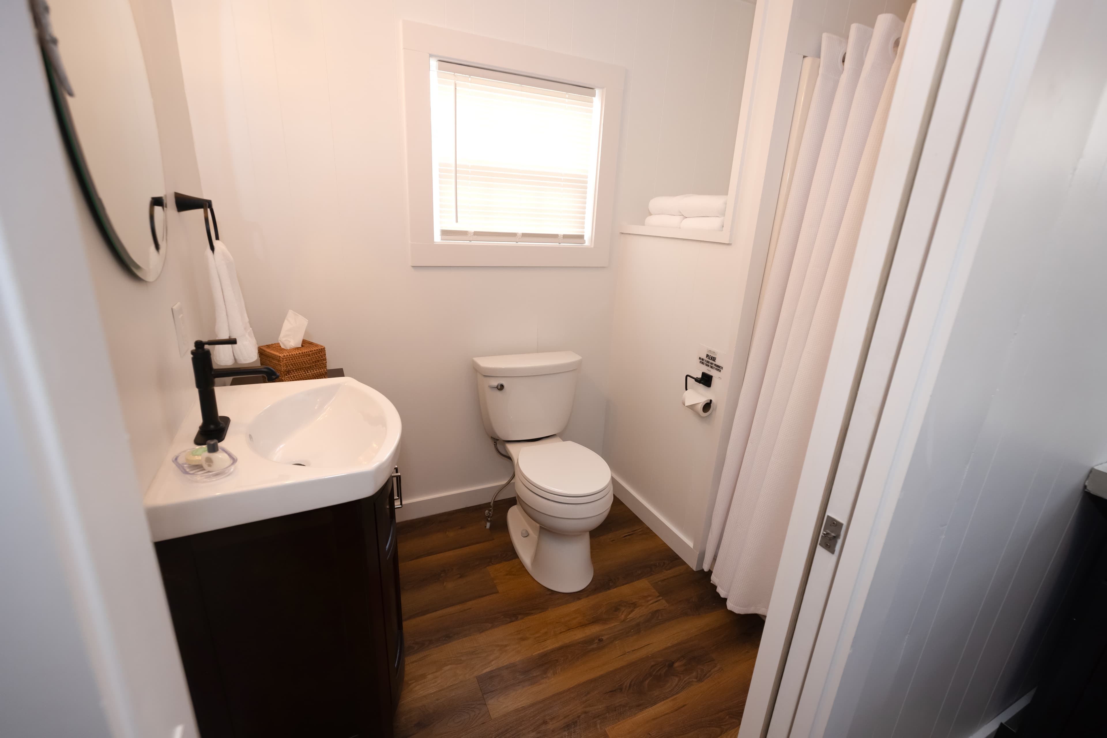 bathroom with window, single shower, toilet and sink vanity