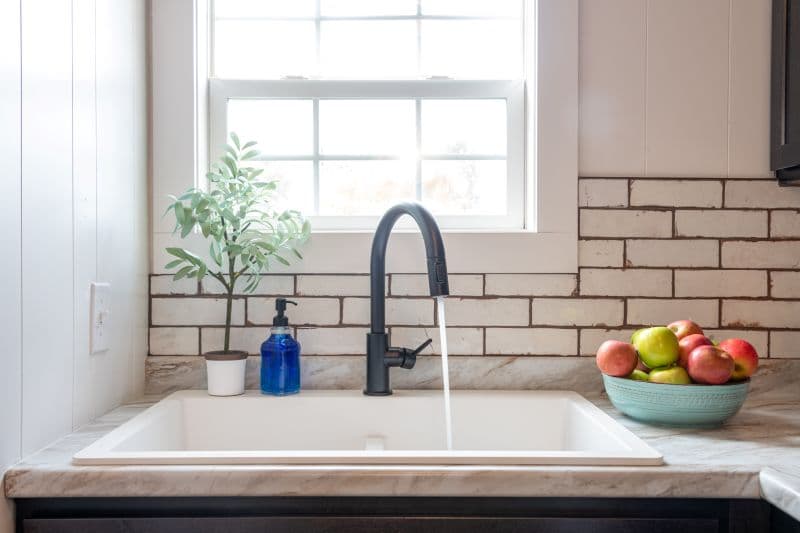kitchen sink with a window and a bowl of apples