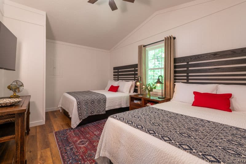 bedroom with two queen beds, a tv and table underneath