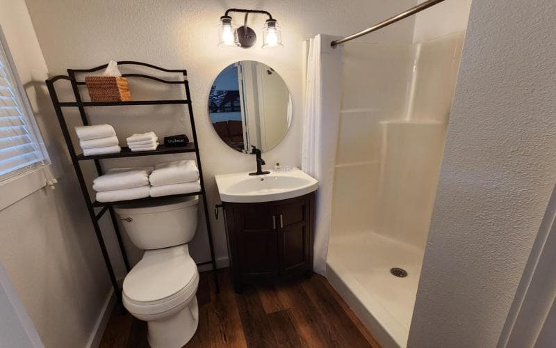 private bath with full shower, toilet, and sink vanity