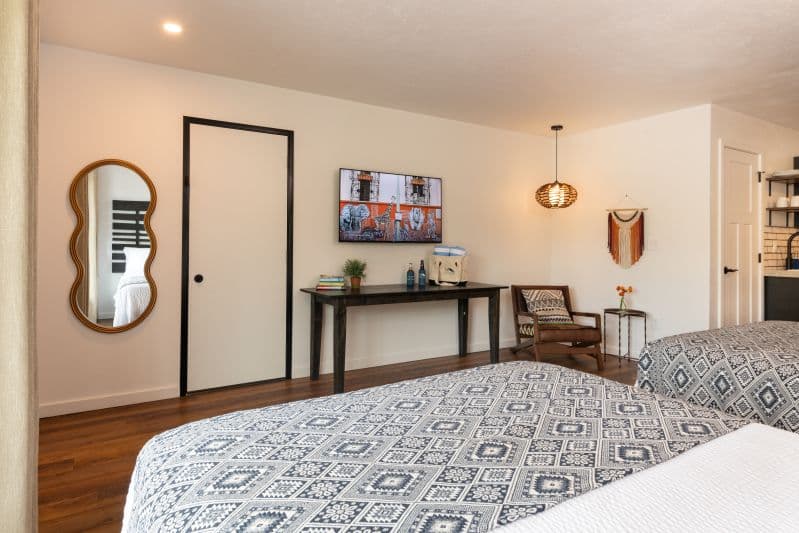 two beds with a mounted tv and a table underneath