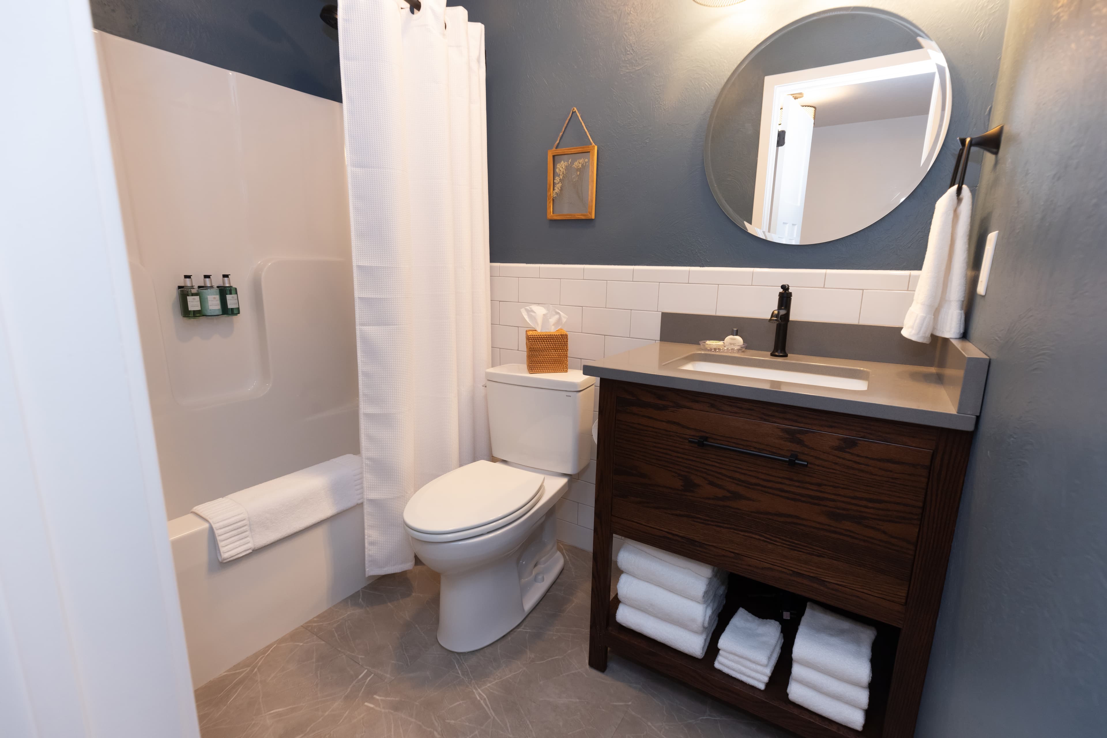 hotel bathroom with sink, toilet and tub shower combination