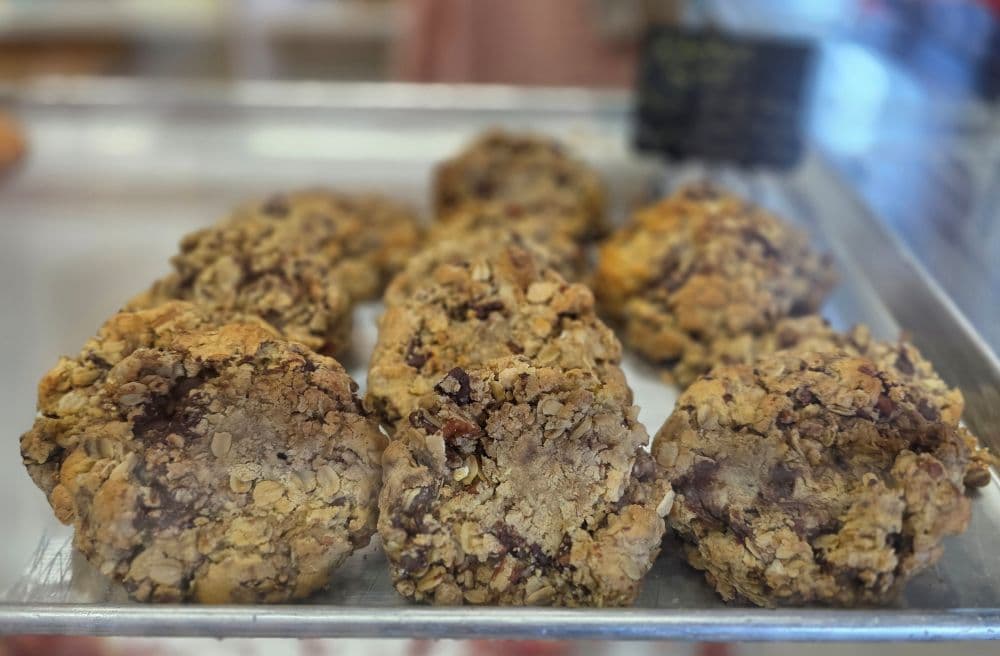 A tray of freshly baked oatmeal cookies with chocolate chunks.