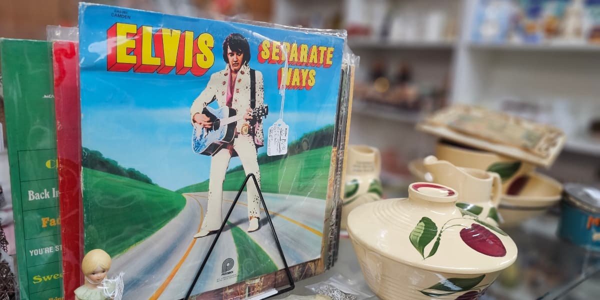 A vintage vinyl record of Elvis Presley titled "Separate Ways" displayed among assorted collectibles.