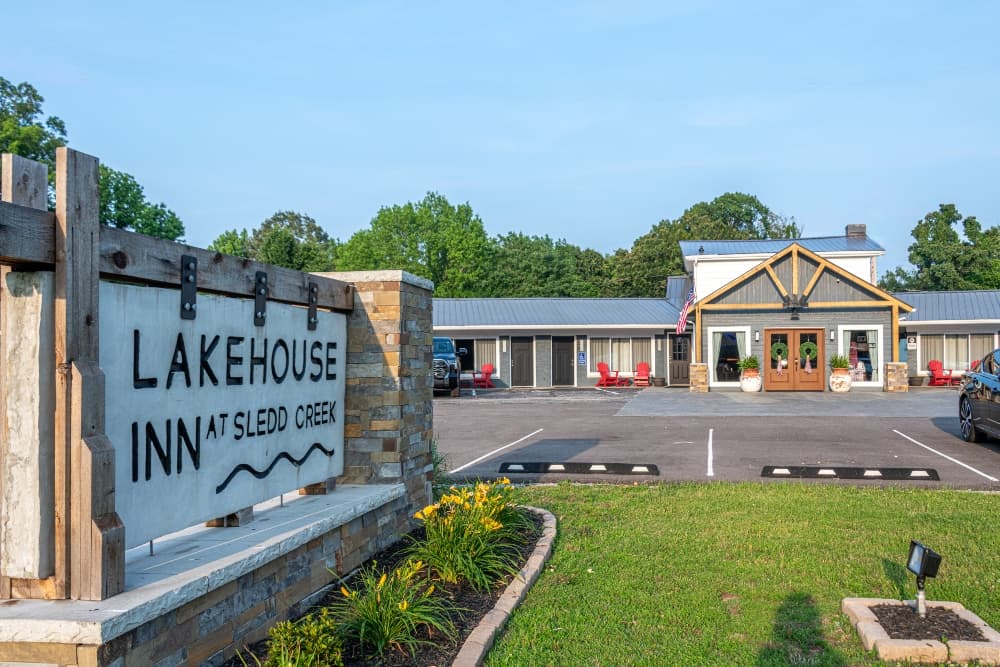 Sign for Lakehouse Inn at Sledd Creek in front of a building surrounded by greenery.