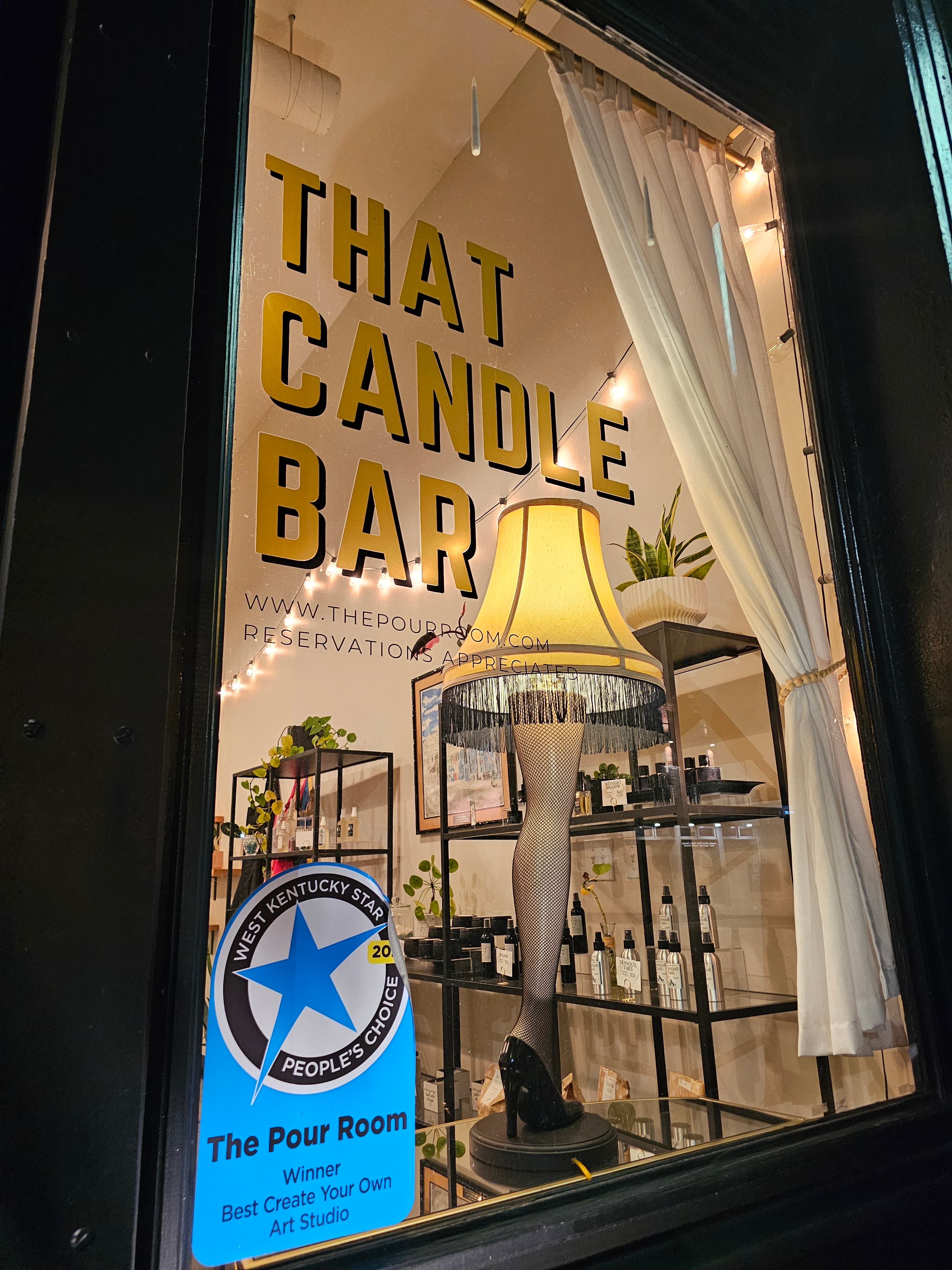 A window display for "That Candle Bar" features a decorative lamp and shelves of candle-making supplies.