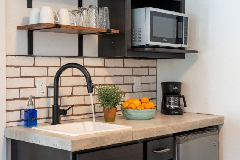 kitchenette with microwave, refrigerator, coffeemaker, toaster and dishes