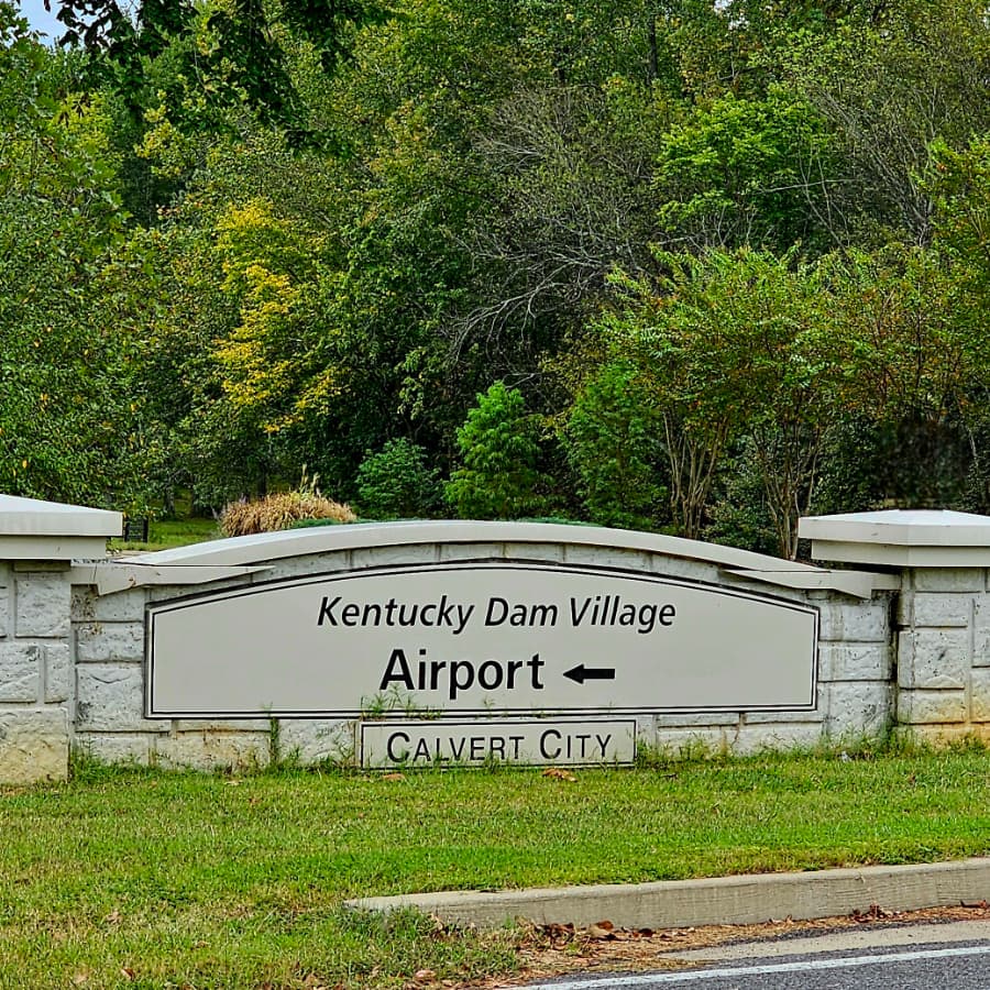 Sign for Kentucky Dam Village Airport, pointing left towards Calvert City.