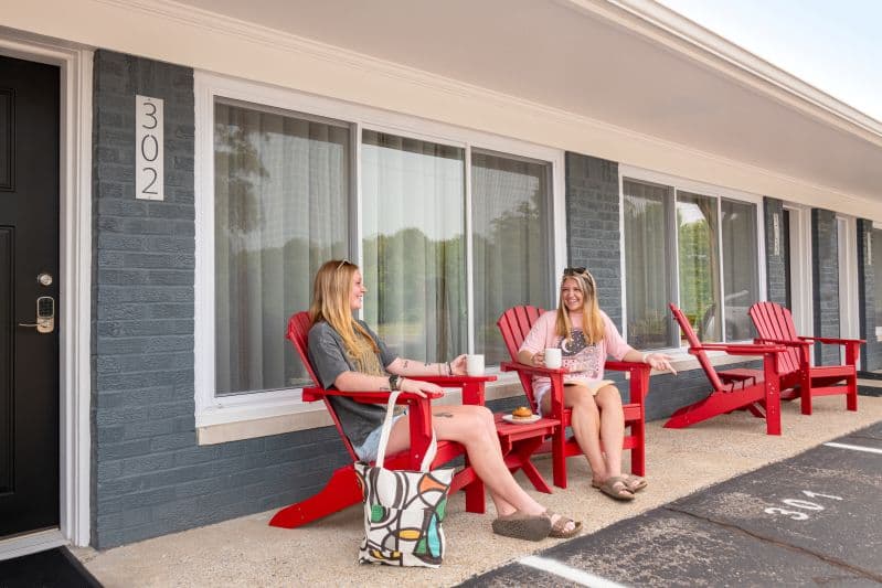 exterior door with two models in red adirondack chairs
