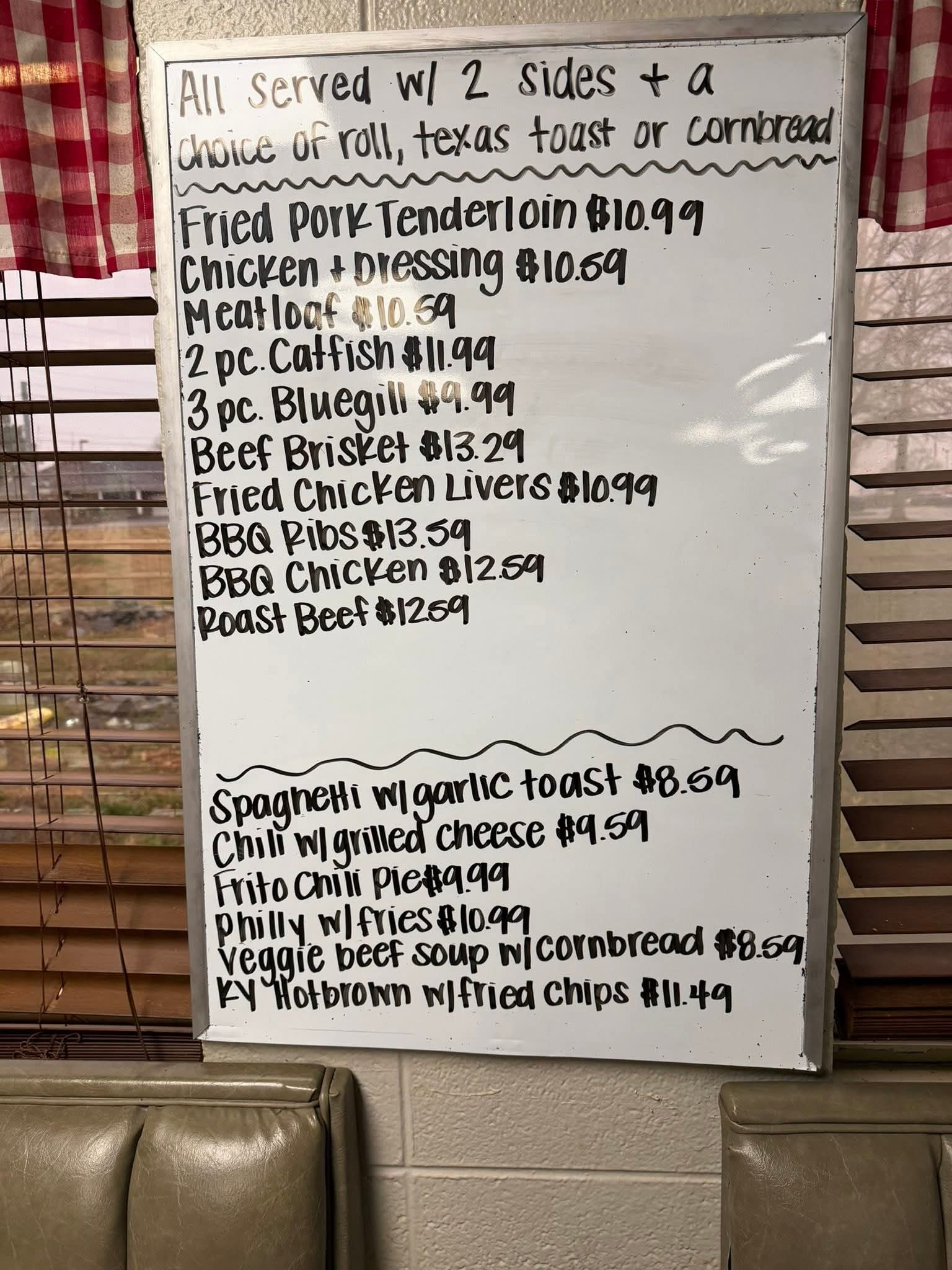 Menu board listing various dishes and prices, including fried pork tenderloin, BBQ ribs, and spaghetti with garlic toast.