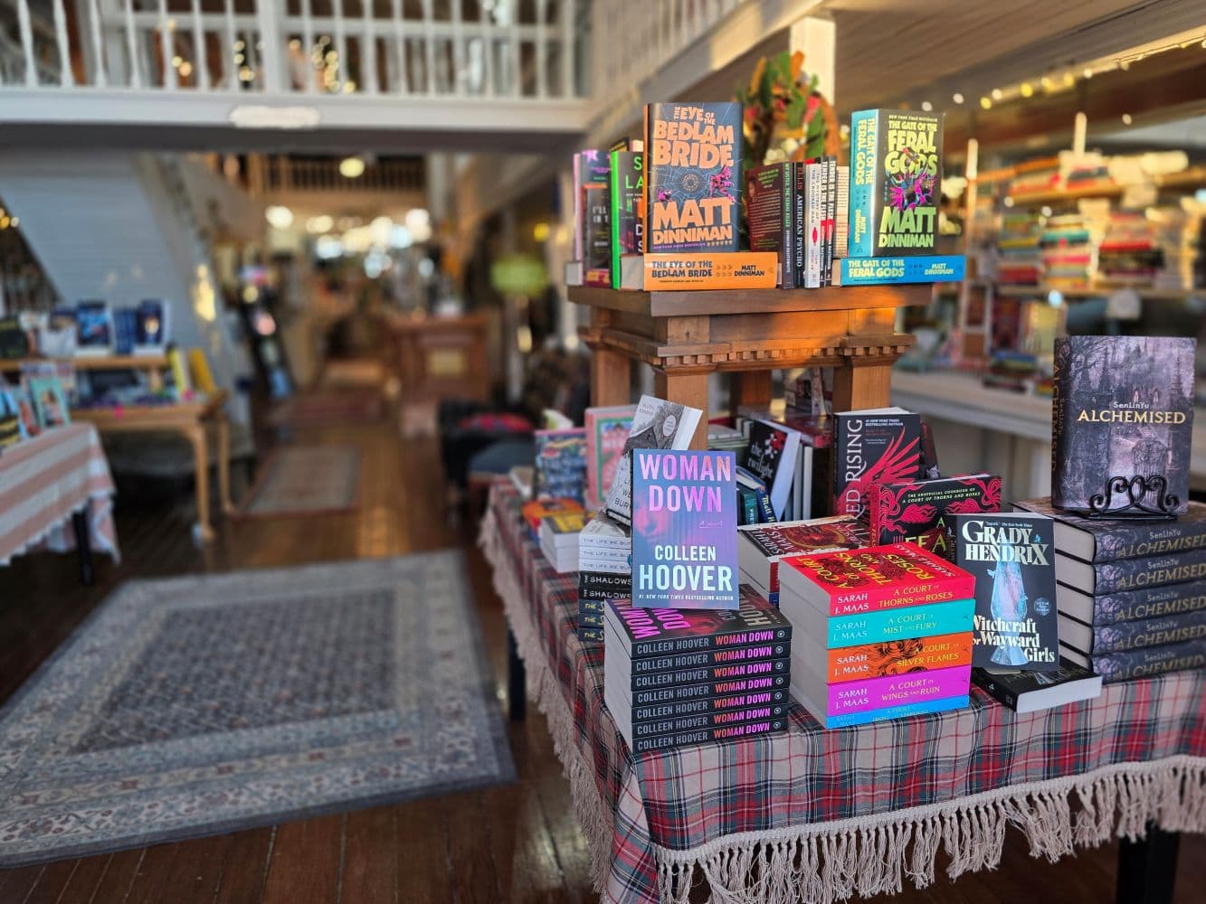 A cozy bookstore interior featuring a display of various books on a table with an inviting atmosphere.