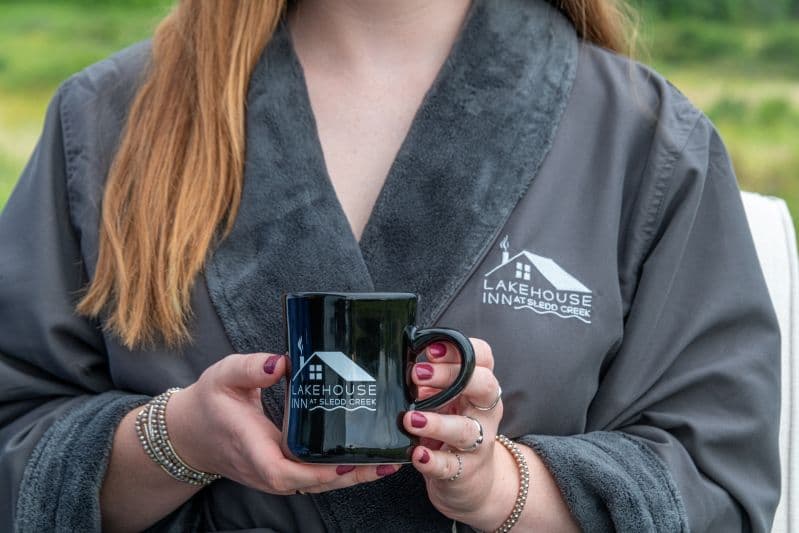 model in spa robe with cup of coffee