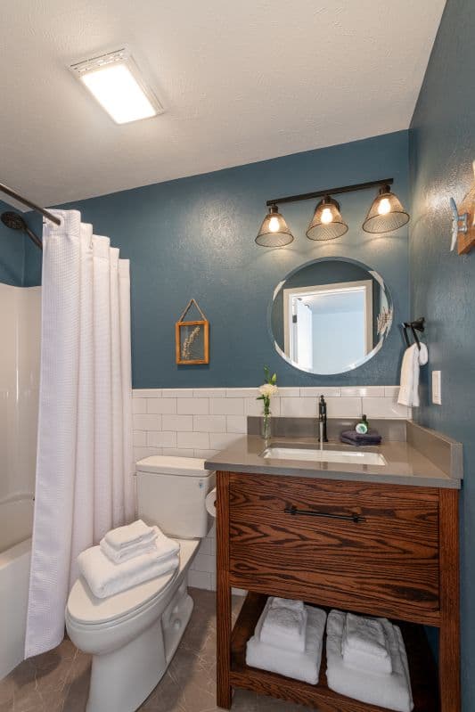 private bath with tub shower combination, toilet and sink vanity
