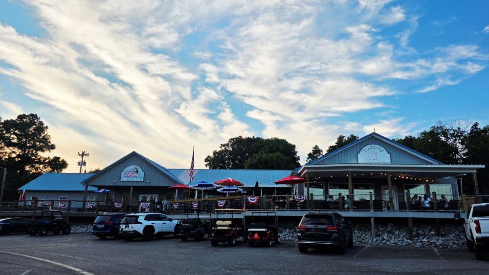 view of Ralph's Harborview Restaurant from the parking lot with the sun setting behind it